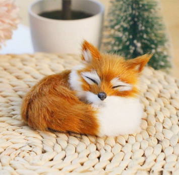 Лиса на торпеду лежащая на коврике коричнево-белая